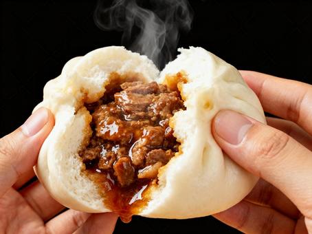 両手で割った熱々肉まんをクローズアップ 両手で割った熱々肉まんをクローズアップの写真