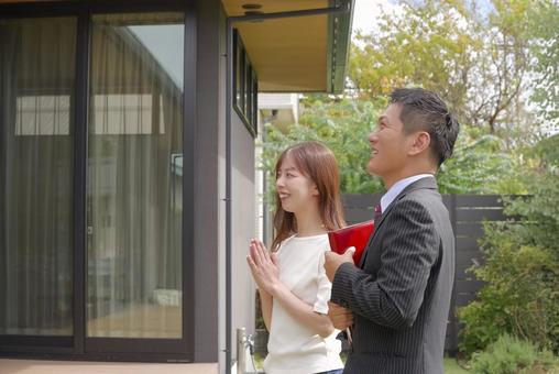モデルハウスの案内をするスタッフと女性 モデルハウスの案内をするスタッフと女性 住まい探し,物件探し,家探しの写真素材