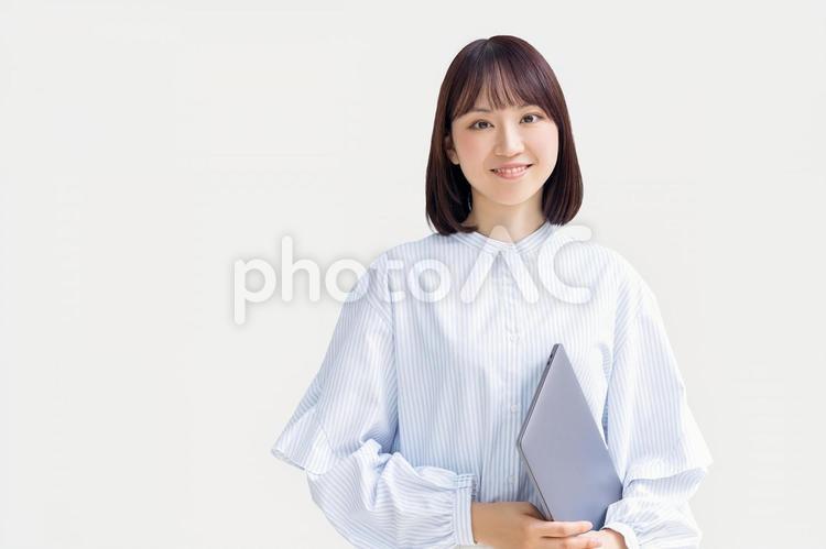 ノートパソコンを持つ笑顔の女性 女性,人物,パソコンの写真素材