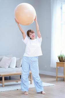 カメラ目線でバランスボールを持つ女性 女性,バランスボール,持つの写真素材