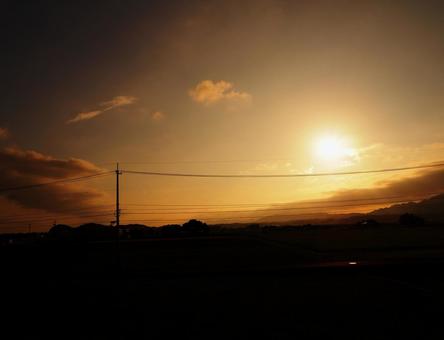 田園に沈む夕日と遠くの山並み 田園に沈む夕日と遠くの山並み 夕日,夕焼け,田舎の写真素材