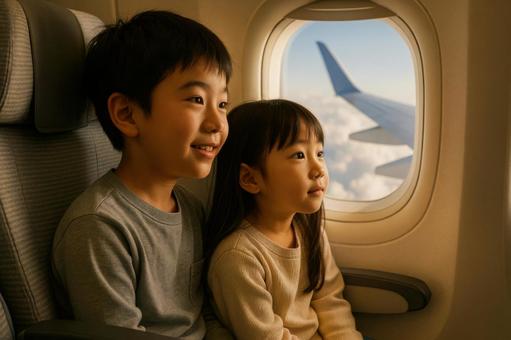 機内で窓の外を眺める日本人兄妹 機内で窓の外を眺める日本人兄妹の写真