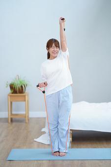 トレーニングチューブを伸ばす女性 女性,トレーニングチューブ,ゴムチューブの写真素材