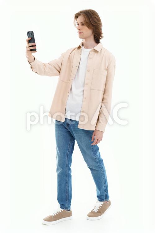 右手でスマホを持ち見ている男性 男性,スマートフォン,持つの写真素材