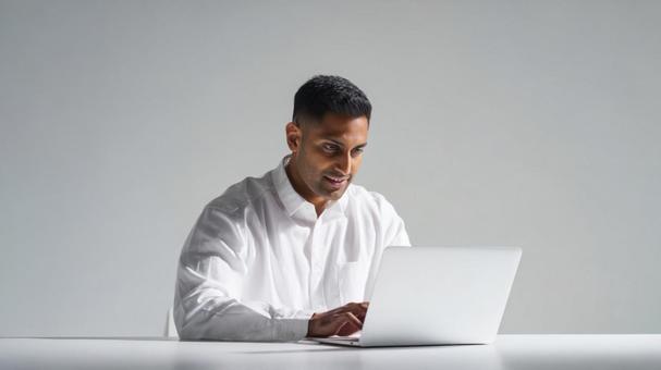 パソコン作業中の明るい表情の男性 パソコン作業中の明るい表情の男性の写真