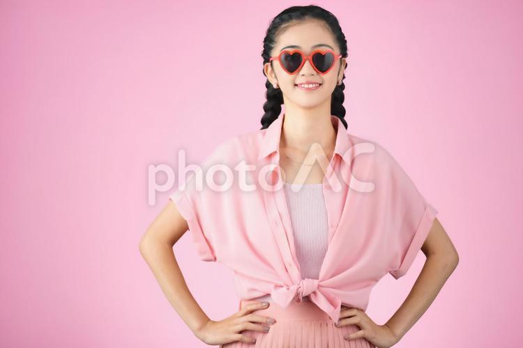 ピンク背景でハートのサングラスをかけている女性 女性,日本人,ポートレートの写真素材