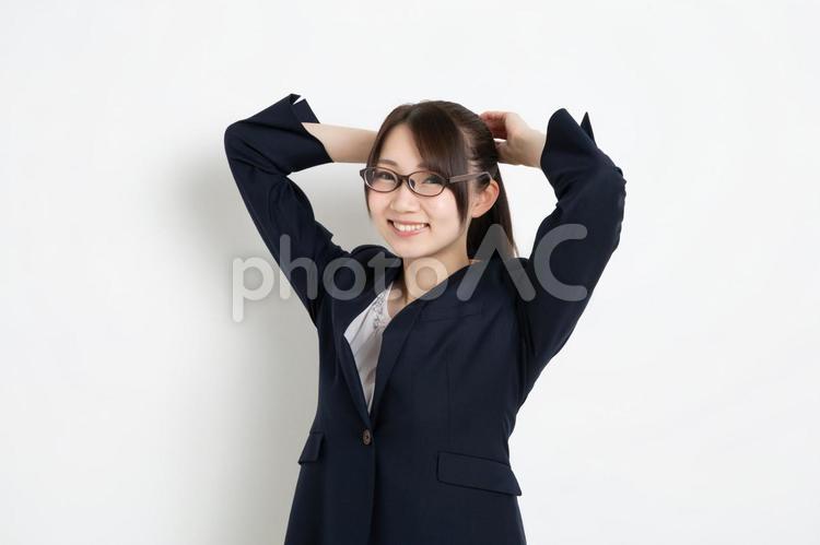 髪を解こうとしているメガネのビジネスウーマン 女,女性,日本人の写真素材