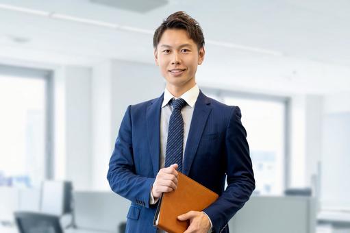 バインダーを持つ笑顔の男性ビジネスマン 男性,ビジネス,ビジネスマンの写真素材