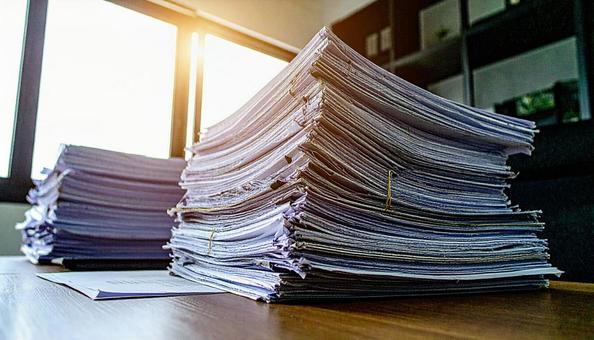 書類まみれの会社の机 書類まみれの会社の机の写真