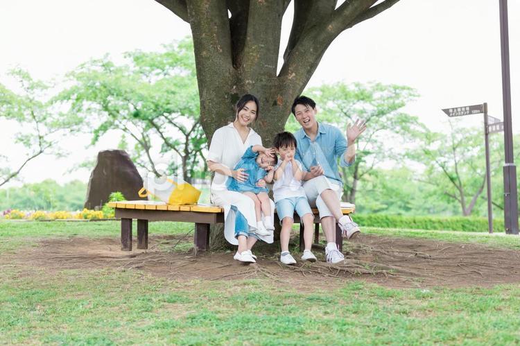 公園のベンチに座る家族 公園のベンチに座る家族 人物,家族,女性の写真素材