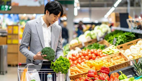 スーパーで野菜を買う日本人ビジネスマン スーパーで野菜を買う日本人ビジネスマンの写真