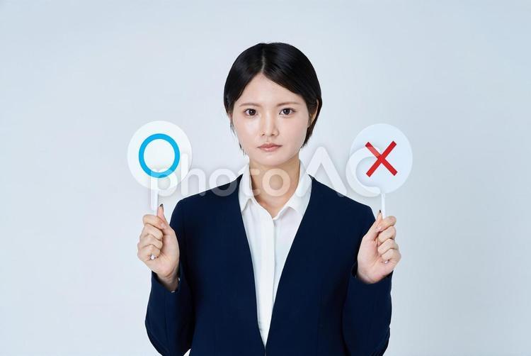 マルとバツのプレートを持つスーツ姿の女性 女性,若い女性,ビジネスウーマンの写真素材