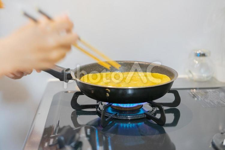キッチンでフライパンを使って卵焼きを作る キッチン,主婦,朝ごはんの写真素材