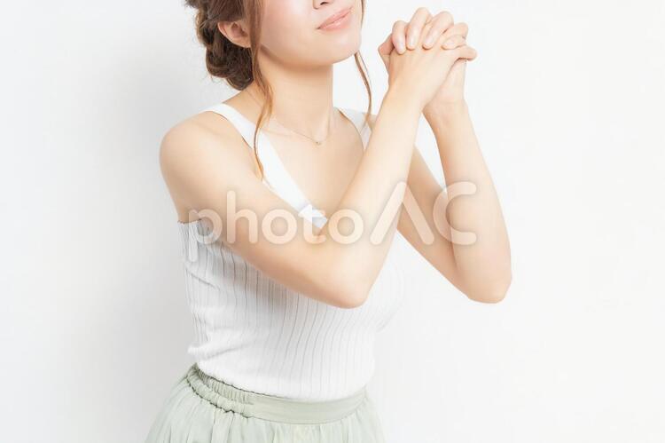 お願いのジェスチャーをする若い女性 女性,ポーズ,お願いの写真素材