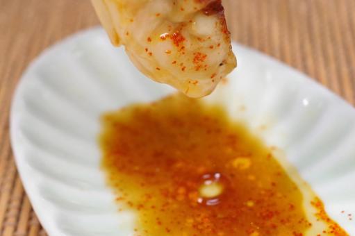 タレを付けた餃子を持ち上げたところ タレを付けた餃子を持ち上げたところの写真