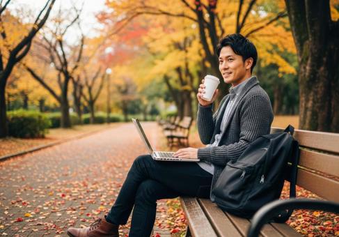 秋の公園でリモートワークする男性 秋の公園でリモートワークする男性の写真