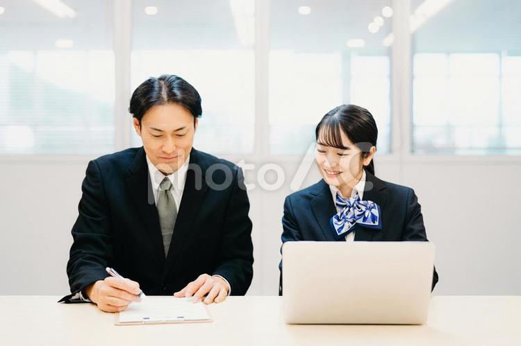 パソコンを使うビジネスシーンの男女 パソコン,相談,研修の写真素材