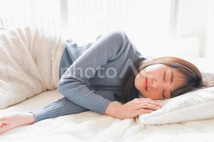 布団に入って睡眠を取る若い女性 日本人,回復,リラックスの写真素材