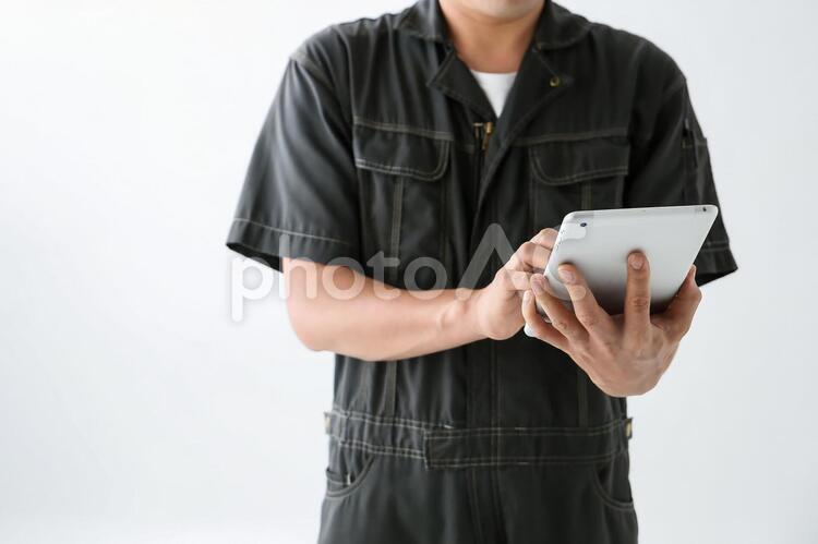 タブレットを操作する作業着の男性 1人,30代,ftd0011の写真素材