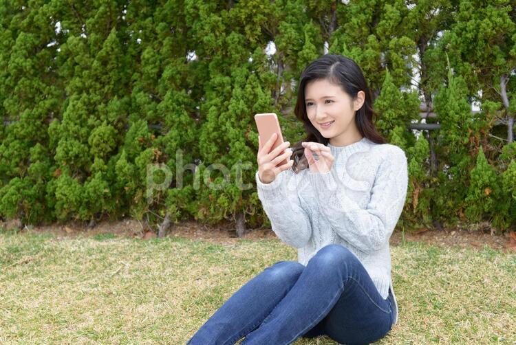 スマートフォンを持つ笑顔の女性 女性,女,笑顔の写真素材