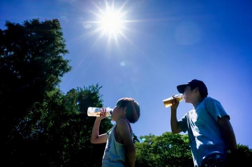 <素材>公園遊び中に水筒のお茶を飲む兄弟 <素材>公園遊び中に水筒のお茶を飲む兄弟の写真