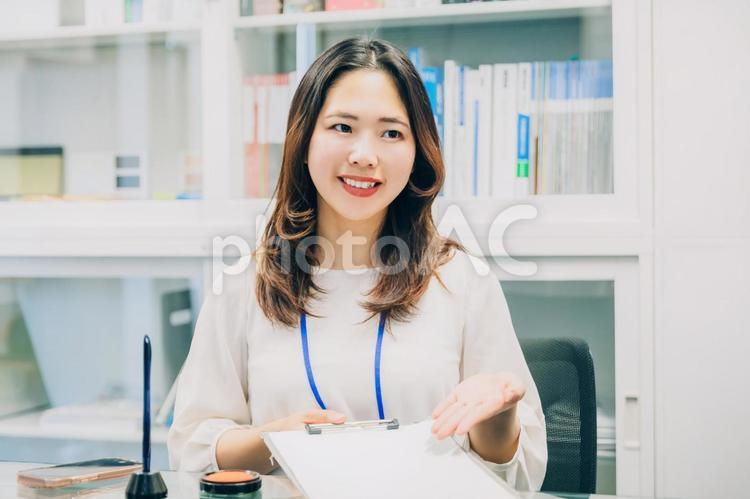 書類にサインをお願いするビジネスウーマン 頑張る女性,ノートパソコン,20代女性の写真素材