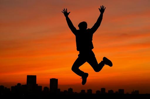 ジャンプするシルエット人物の写真