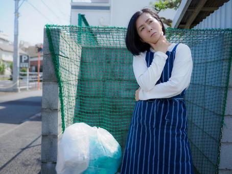 34:ゴミ捨てのマナーに戸惑う女性 34:ゴミ捨てのマナーに戸惑う女性の写真
