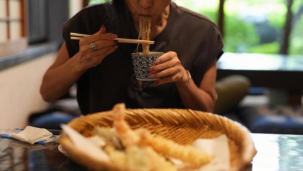 蕎麦を食べる女性とてんぷら 蕎麦を食べる女性とてんぷらの写真