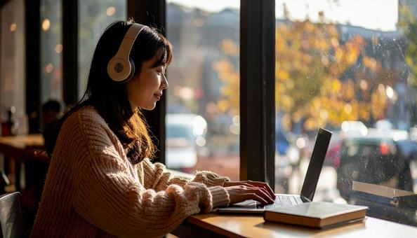 お気に入りの音楽を聴きながら勉強する女性 お気に入りの音楽を聴きながら勉強する女性の写真
