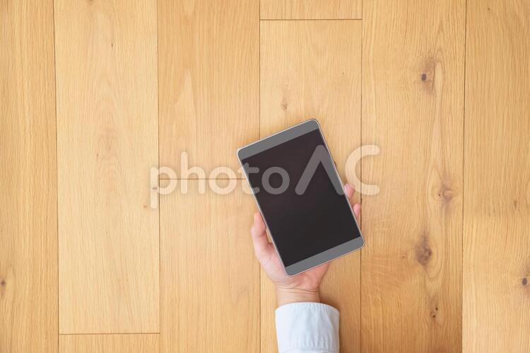 タブレットを手にする男性の手-茶色の木目デスク ビジネス,男性,日本人の写真素材