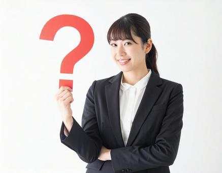 クエスチョンマークをもつスーツ姿の女性 クエスチョンマークをもつスーツ姿の女性の写真