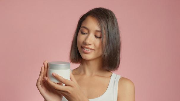クリームジャーを持って笑顔の女性 クリームジャーを持って笑顔の女性 女性,外国人,アジア人の写真素材