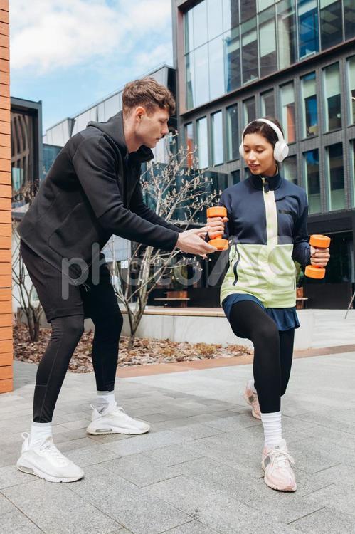 ダンベルを持った女性に指導する男性 男性,女性,ダンベルの写真素材