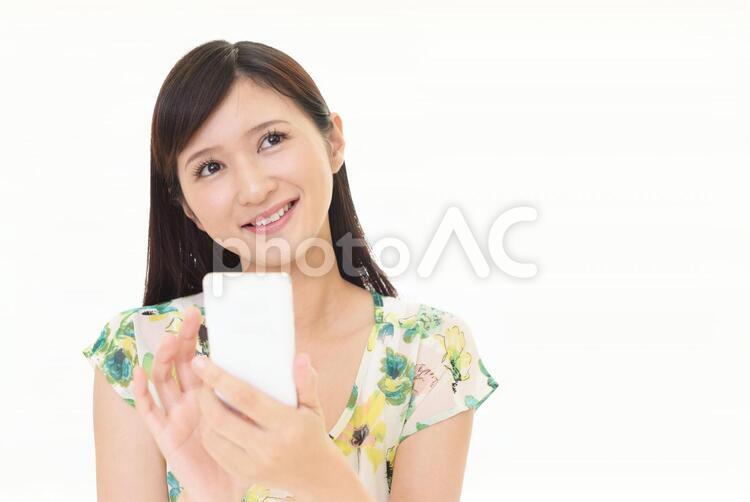 スマートフォンを持つ笑顔の女性 女性,スマートフォン,女の写真素材