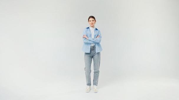 腕組みをして立つカジュアルファッションの女性 腕組みをして立つカジュアルファッションの女性の写真