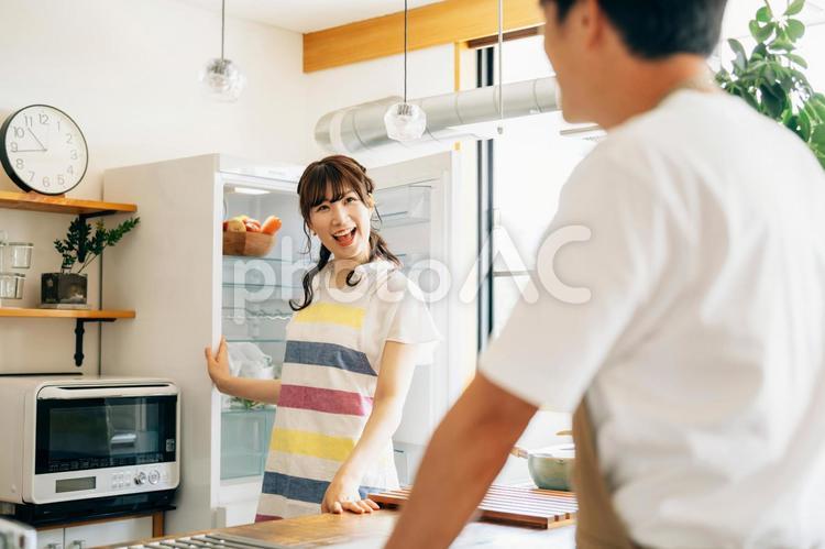 冷蔵庫の前に立つ女性と男性 冷蔵庫,夫婦,料理代行の写真素材