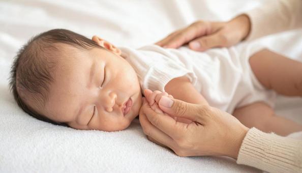 赤ちゃんの手を握る日本人お母さんの手 赤ちゃんの手を握る日本人お母さんの手の写真