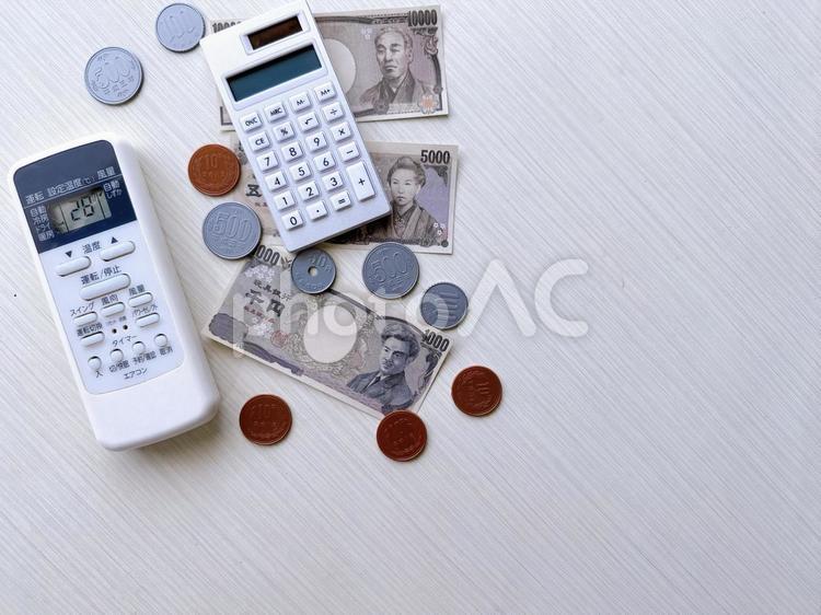 エアコンのリモコンとお金　電気代　光熱費 エアコン,電気代,光熱費の写真素材