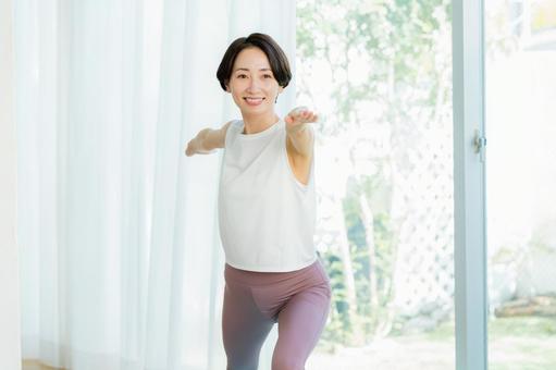 リビングでヨガをする女性 ヨガ,笑顔,女性の写真素材