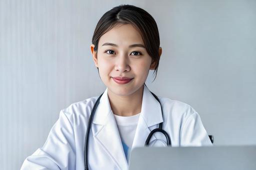 ノートパソコンを使う女性医師 ノートパソコンを使う女性医師の写真