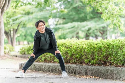 運動前にストレッチ・準備体操する若い男性 屈伸,ストレッチ,準備体操の写真素材