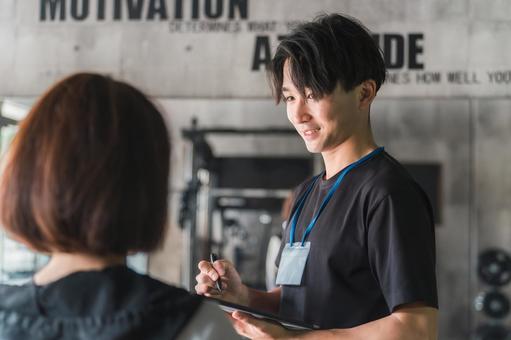 運動メニューの指導をする男性トレーナー ジム,スポーツジム,運動メニューの写真素材