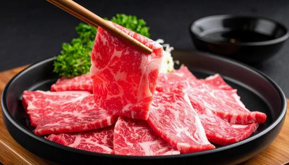 焼肉用の生肉を箸でつまむ 焼肉用の生肉を箸でつまむの写真