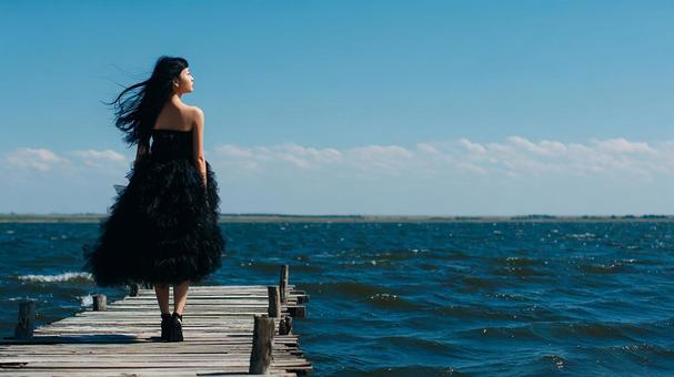風に揺れるドレスと広がる海の風景 風に揺れるドレスと広がる海の風景の写真