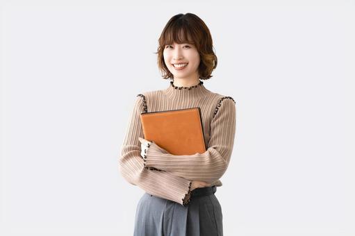 バインダーを持つ笑顔のビジネスウーマン バインダーを持つ笑顔のビジネスウーマン 女性,笑顔,ビジネスの写真素材