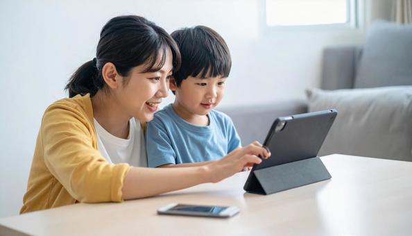 タブレットの画面を見る日本人親子 タブレットの画面を見る日本人親子の写真