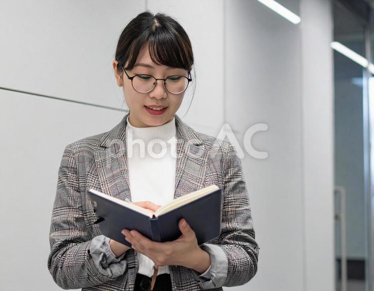 歩きながらノートに書くビジネスウーマン ビジネス,女性,人物の写真素材
