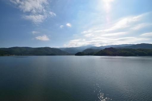 太陽が輝く夏の猪苗代湖と山々の絶景 太陽が輝く夏の猪苗代湖と山々の絶景の写真
