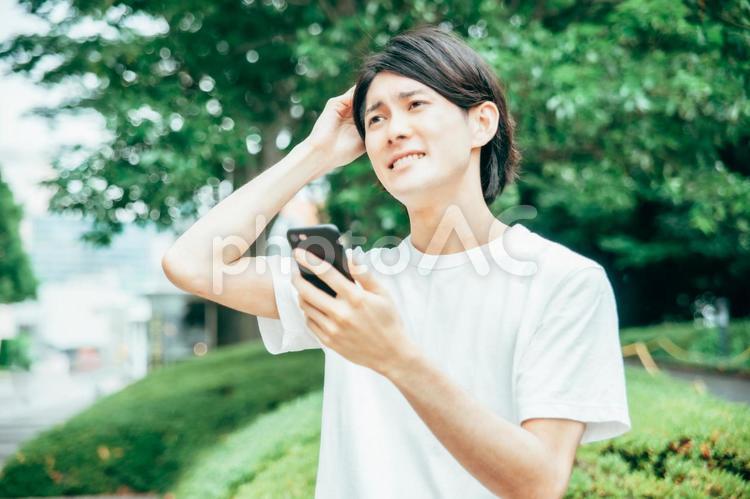 スマホを使う男性（困る） スマホ,アプリ,困るの写真素材